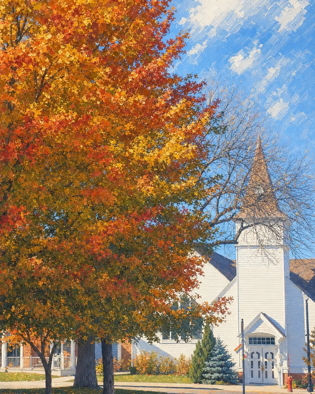A white church behind a fall maple